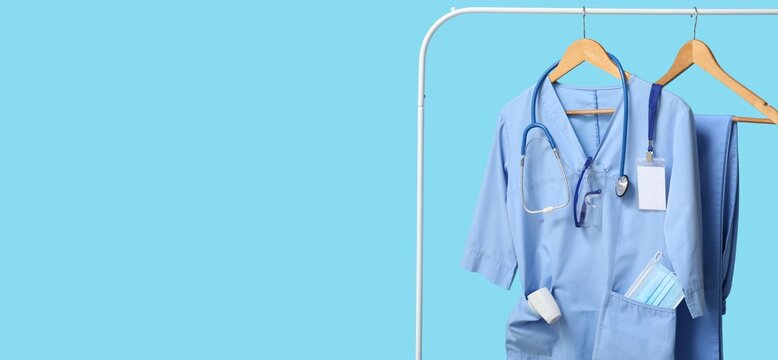 Healthcare worker burnout and medical staff shortage, blue scrubs with stethoscope and protective gear hanging on a rack for hospital shift preparation