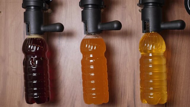 A bar counter with draft beer. Draft beer is served in plastic bottles. There are three different types of draft beer bottled in these disposable bottles. 