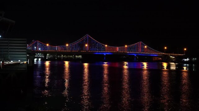 Night illumination of Sri Tapee Bridge over Tapi River in Surat Thani, Thailand 