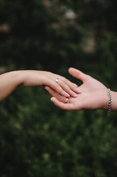 Wedding photo of the newlyweds, the groom and the bride touching each other with their hands and fingers.