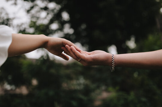 A close-up wedding photo of the newlyweds, the bride and groom touching each other with their hands and fingers.