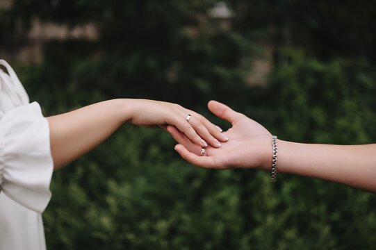 A close-up wedding photo of the newlyweds, the bride and groom touching each other with their hands and fingers.