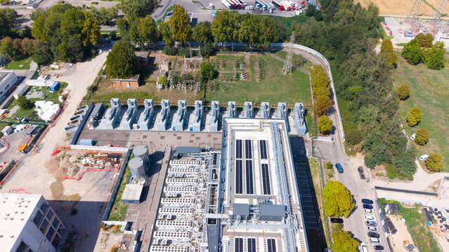 Aerial view of the Equinix Data Center featuring industrial cooling units, rooftop solar panels, and surrounding greenery in Castelletto, Lombardia, Italy.