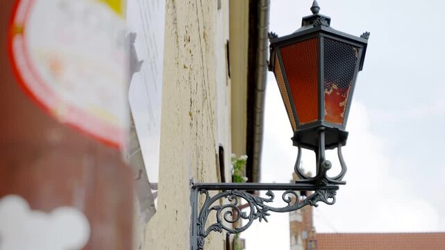 Vintage wall mounted lantern beside an aged building facade in a traditional city street setting