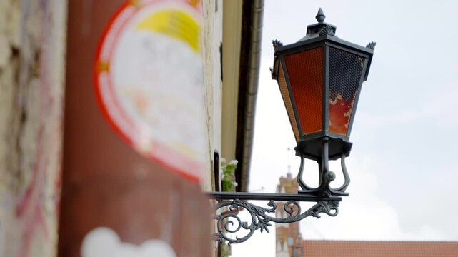 Decorative street lamp mounted on an old city building creating a traditional urban atmosphere