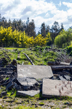 Scattered concrete rubble lies across a grassy patch