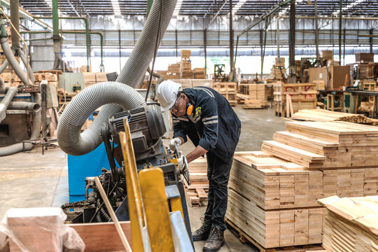 Black male machine engineer adjusting control system parameters on a digital interface screen in modern plywood and timber manufacturing plant