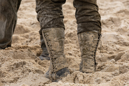 A historical reenactment set during World War II. Close-up. A U.S. infantryman&rsquo;s dirty, sand-covered boots on the beach