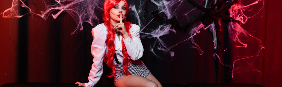 Creepy clown girl cosplay for Halloween with bright red hair and playful spirit, banner