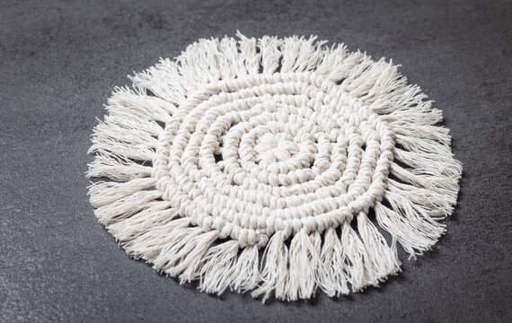 White macrame decorative item with fringe details, finished handicraft.