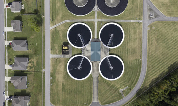 Aerial view of the wastewater treatment plant with circular settling tanks and adjacent residential houses in Gallatin, Tennessee, United States.