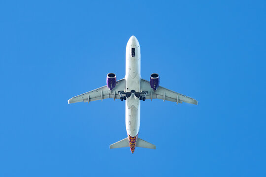 View of a commercial airplane flying overhead against a clear blue sky in Biscay, Basque Country, Spain.