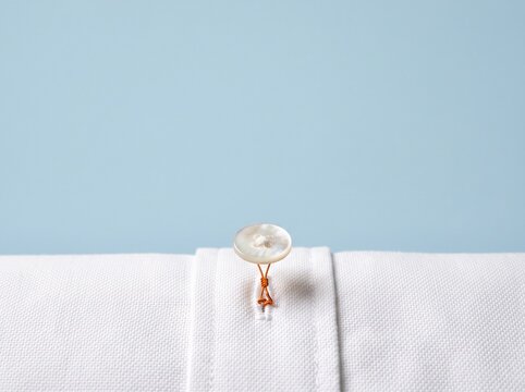 White shirt button fastened on a clean light blue background