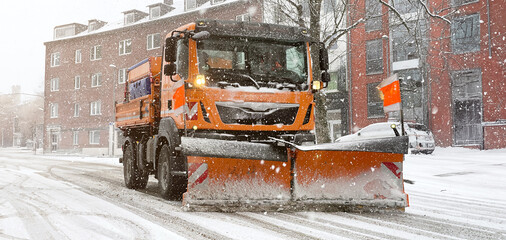 Schneepflug bei Winterdienst räumt Schnee und Eis von den Straßen