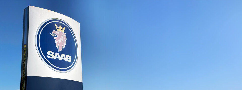 Schild mit Logo des Autoherstellers SAAB vor blauem Himmel