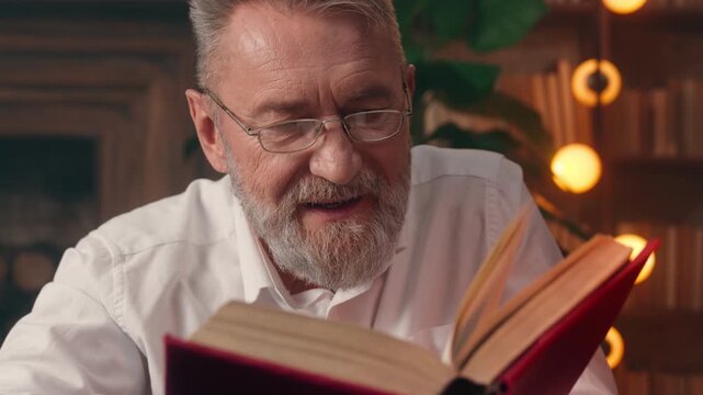 Happy cheerful Caucasian senior old business man reading book turning pages in textbook retired businessman male reader citizen read at evening library carefree elderly professor teacher enjoy hobby