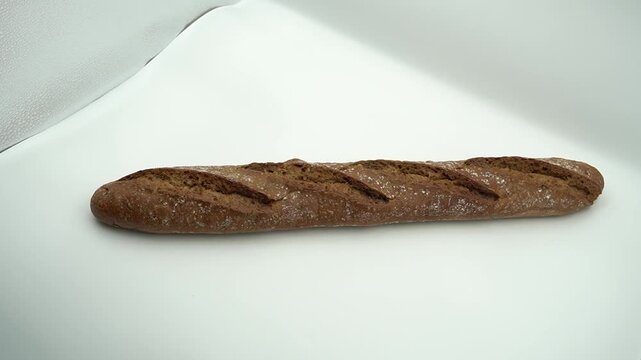 Artisan whole wheat French baguette loaf isolated on a white background