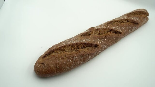 Artisan whole wheat French baguette loaf isolated on a white background