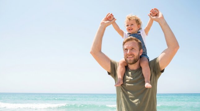 Toddler daughter riding piggyback on father's shoulders at a sunny beach