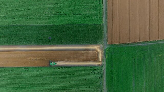 Aerial farmland landscape with a combine harvester and rural tracks
