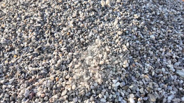 crushed stones trickle onto a pile