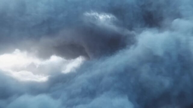 Swirling storm cloud formation opens around a bright patch of light in the sky