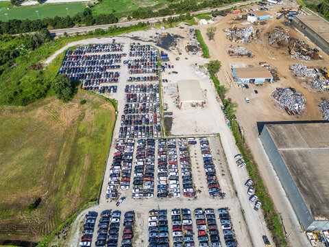 Aerial view of Cape Fear Pick N Pull salvage yard featuring rows of parked cars, scrap metal piles, and industrial buildings in Wilmington, North Carolina, United States.