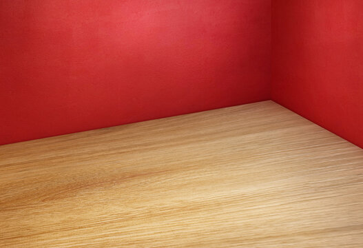 Minimalist wood table with red wall background for product display.