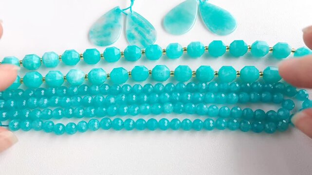 Selection of vibrant blue amazonite gemstone beads arranged neatly alongside matching polished stone earrings