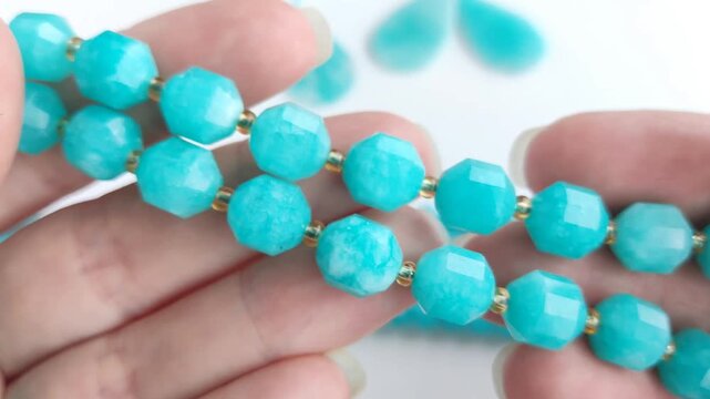 Vibrant turquoise amazonite gemstone beads and matching polished teardrop pendants displayed on a clean white surface for jewelry making and craft design projects