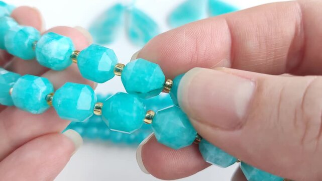 Vibrant turquoise amazonite gemstone beads and matching polished teardrop pendants displayed on a clean white surface for jewelry making and craft design projects