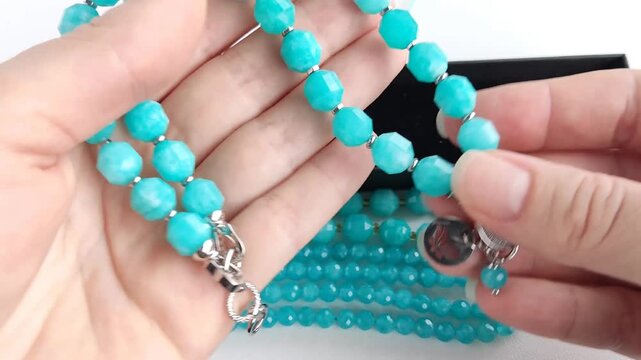 Vibrant turquoise amazonite gemstone beads and matching polished teardrop pendants displayed on a clean white surface for jewelry making and craft design projects
