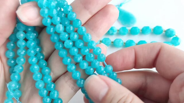 Vibrant turquoise amazonite gemstone beads and matching polished teardrop pendants displayed on a clean white surface for jewelry making and craft design projects
