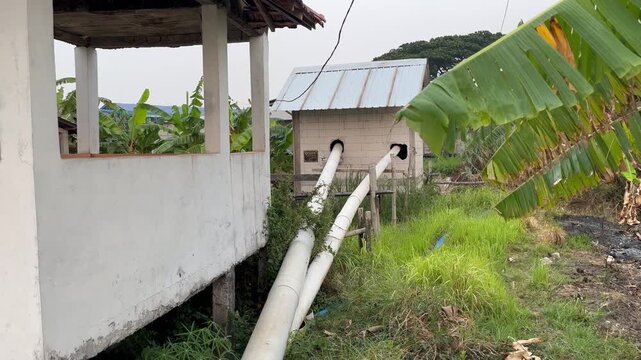 Large white PVC drainage pipes installation from concrete building