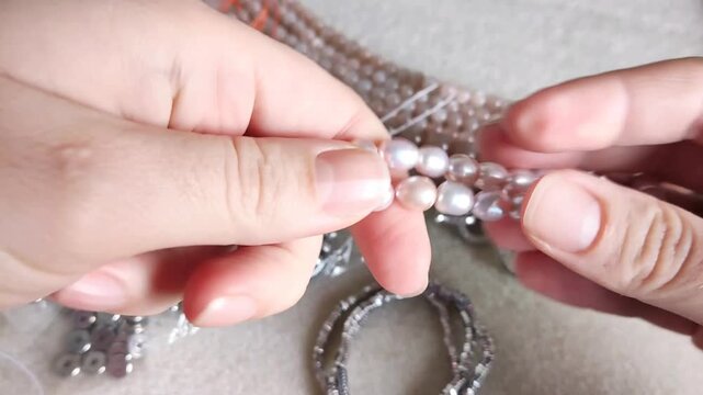 Premium collection of polished natural pink and beige gemstone spherical bead strands organized alongside metallic components and jewelry findings for artisan crafting projects and custom accessory cr