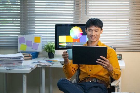 Creative Graphic Designer Working with Digital Tablet and Color Wheel on Monitor in Modern Office Workspace