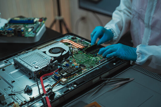 Technician Soldering Circuit Board with Magnifying Glass at Electronics Repair Station