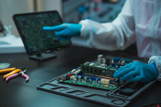 Technician Soldering Circuit Board with Magnifying Glass at Electronics Repair Station