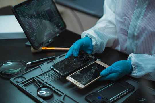 Technician Disassembling Mobile Phone with Precision Tools at Repair Workstation