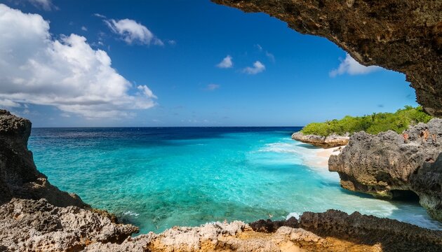 Vista Do Mar Do Caribe Em Curacao Atraves De Uma Abertura Rochosa Revelando Praia Isolada Ondas Suaves E Cenario Tropical Paradisiaco