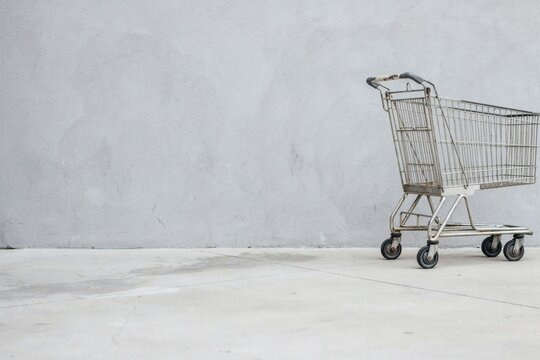 Side view of an empty wire shopping trolley on a bare concrete floor