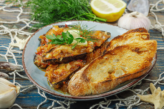 Mediterranean seafood concept. Mussels cooked in tomato salsa sauce with toasted bread, lemon, herbs