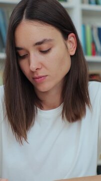 Student collecting information from different books, Caucasian girl in white t-shirt gathering data for the paper. Self education concept.
