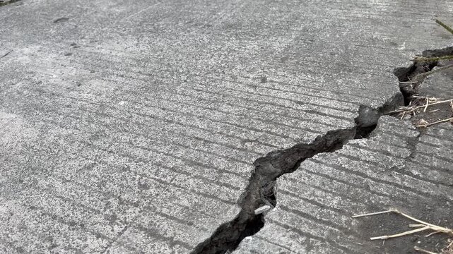 Deep crack on gray concrete road surface texture background