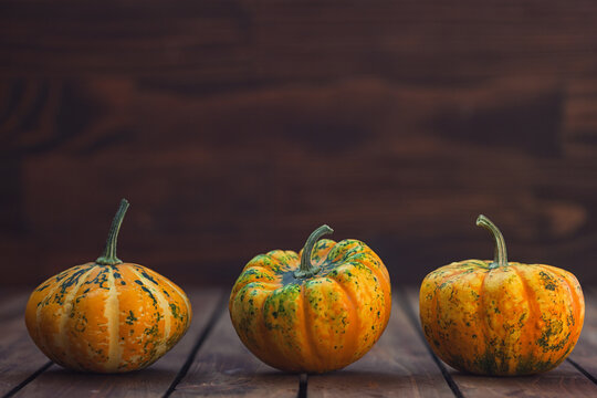 Autumn decorative pumpkins on a wooden background