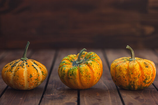 Autumn decorative pumpkins on a wooden background