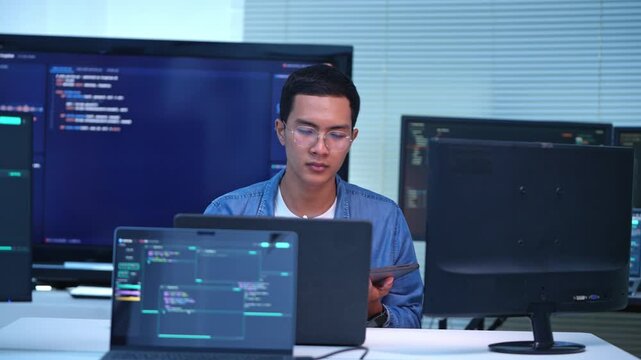 Dedicated software developer participating in a coding conversation at a contemporary tech office featuring several monitors