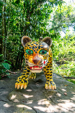 Colorful jaguar statue in lush tropical forest