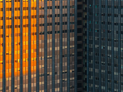 Aerial view of the modern facade of a building in the EUR district featuring vertical architectural lines and golden sunlight reflecting off the windows in Rome, Lazio, Italy.