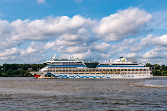 HAMBURG, GERMANY - JULY 5, 2026: Side view of AIDAsol luxury cruise ship sailing on Elbe River under blue cloudy sky, maritime tourism and cruise travel editorial concept